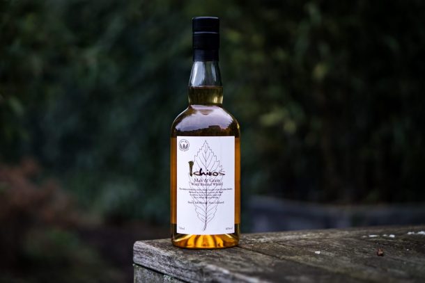 Bottle of Ichirt Malt Grain sitting on wooden table with trees in the background