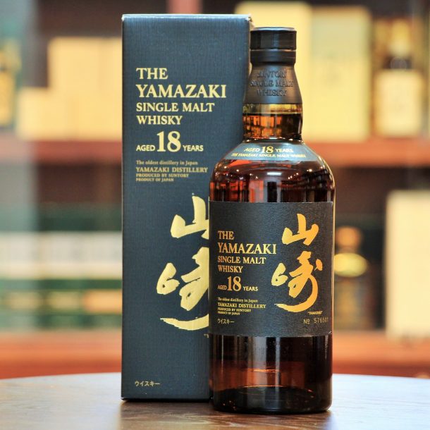 Portrait-style shot of Yamakazi 18 Year bottle next to case with blurred background