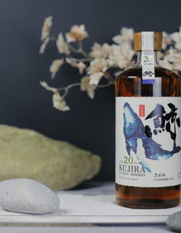 Kujira 20 year display with cherry blossoms and stones on a marble counter
